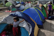 Un niño sale de una tienda en el improvisado campamento de la frontera griega con Macedonia cerca de Idomeni.-DANIEL MIHAILESCU