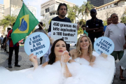 Dos activistas de la organización Personas a favor del Trato Ético a los Animales (PETA, en inglés) se bañan en una tina en el centro de Río de Janeiro hoy para denunciar que el consumo de carne supone el despilfarro de grandes cantidades de agua.-EFE / Fernando Maia