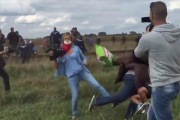 Fotograma en el que se puede ver a la reportera zancadilleando a un refugiado con un niño en brazos.-EL PERIÓDICO