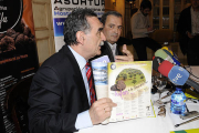 Anselmo García, de Soriactiva, muestra la revista en presencia de Ángel Mayor, presidente de Asohtur. /  VALENTÍN GUISANDE-