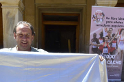 Fermín Cacho posa junto a la bandera de Soria frente al Ayuntamiento capitalino. / ÁLVARO MARTÍNEZ-