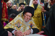 El patriarca Bartalomeo I firma el documento de escisión en la iglesia de San Jorge, en Estambul.-EFE / MYKOLA LAZARENKO