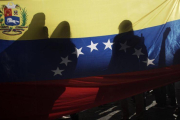 La bandera venezolana, entre sombras en una protesta en Costa Rica.-EFE/JEFFREY ARGUEDAS