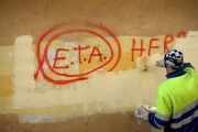 Un operario borra una pintada en la que aún se puede leer ETA, en una imagen de archivo.-REUTERS