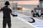 Un mecánico de Sauber espera a su monoplaza en la calle de boxes con la piruleta en sus manos.-JOSÉ MARÍA RUBIO