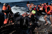 La reacción de un refugiado al llegar a la isla griega de Lesbos, este miércoles.-ARIS MESSINIS / AFP