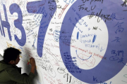 Un hombre escribe sus condolencias por las víctimas del vuelo MH370 de Malaysia Airlines en el aeropuerto internacional de Kuala Lumpur en marzo del 2014.-MAK REMISSA