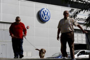 Unos hombres pasean frente a un concesionario de Volkswagen en Sevilla, ayer.-REUTERS