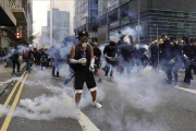 Manifestantes frente a los gases lacrimógenos lanzados por la policía en Hong Kong.-AP / VINCENT YU