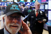 Un operador de Wall Street luce una gorra conmemorativa de los 25.000 puntos alcanzados por el Dow Jones.-LUCAS JACKSON