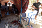 Varios iraquís inspeccionan la tienda donde se ha cometido el atentado suicida, en el barrio de Shaab, en Bagdad, este sábado.-EFE / ALI ABBAS