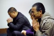 Familiares de los pasajeros del vuelo de Malaysia Airlines rezan, en un hotel de Pekín.-AFP / WANG ZHAO