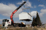 Una grúa levanta, ayer, una casa prefabricada del asentamiento de Amona, desmantelado por Israel.-AFP / THOMAS COEX