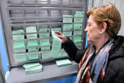Una mujer elige una papeleta en las un colegio electoral de Almería.-EFE / CARLOS BARBA