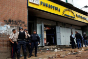 Agentes de policía frente a la panadería asaltada en Caracas, el 21 de abril.-REUTERS / CARLOS GARCIA RAWLINS
