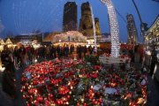 Altar de flores y velas en el mercadillo navideño de Berlín, que ayer reabrió.-AP / MARCUS SCHREIBER