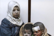Una mujer abraza a sus hijos tras resultar todos heridos en un bombardeo en el barrio de Al Barze.-SARIEH ABU ZAID / EFE