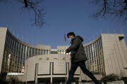 Un hombre pasa por delante de la sede del Banco Central de China, este martes en Pekín.-REUTERS / KIM KYUNG-HOON