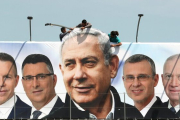 Un grupo de operarios trabaja en una valla publicitaria de propaganda electoral en la que aparece Netanyahu con candidatos de su partido, el Likud, en Jerusalén.-REUTERS / AMMAR AWAD