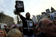 Un manifestante sostiene la foto de Santiago Maldonado, manifestante desaparecido durante unas protestas de apoyo a los indios mapuches.-MARCOS BRINDICCI (REUTERS)