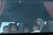 Una mujer y sus hijos, a bordo del autobús que les ha sacado del campo de Idomeni, esta mañana.-AP