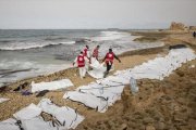Decenas de cuerpos sin vida de inmigrantes alineados en una playa de Zawiya, ayer.-AFP / AMIN ELAMR