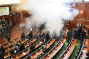 Diputados kosovares evacúan la sala tras el lanzamiento del gas, en la primera sesión parlamentaria del año, en Pristina.-AFP / ARMEND NIMANI