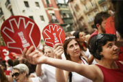 Unas mujeres muestran el símbolo de la campaña contra las agresiones sexistas en Sanfermines durante la manifestación ciudadana.-ÁLVARO BARRIENTOS (AP)