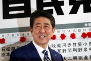 Abe sonríe mientras se dispone a colocar una rosa sobre el nombre de un candidato elegido para la Cámara baja, en la sede de su partido, en Tokio, el 22 de octubre.-REUTERS / KIM KYUNG-HOON