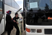 Dos mujeres se disponen a subir a un autocar en el campamento de Idomeni.-AFP / SAKIS MITROLIDIS