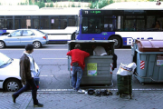 Dos personas recopilan enseres de un contenedor de basura-ICAL