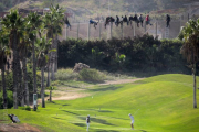 Dos jugadoras en un campo de golf, a pocos metros de la valla de la frontera de Melilla.-Foto: JOSÉ PALAZÓN
