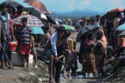 Un refugiado rohinyá lleva a cuestas a un anciano en Bangladés, cerca de la frontera con Birmania-AFP