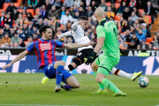 Rodrigo trata de superar a Oliveira y al meta Dmitrovic, en el Valencia-Eibar.-EFE / JUAN CARLOS CÁRDENAS