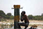 Un trabajador indio se refresca bajo un grifo una calurosa tarde en Amritsar (India).-Foto: EFE / RAMINDER PAL SINGH