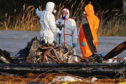 Equipo de forenses junto a la avioneta siniestrada en Erzhausen.-KAI PFAFFENBACH (REUTERS)