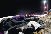 Un inmigrante africano duerme en el suelo, sobre unas piedras, cerca del mar en Ventimiglia, este lunes.-Foto: AP/ MASSIMO PINCA