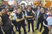 Un grupo de mossos d’esquadra en el instituto Miquel Tarradell, del barrio barcelonés del Raval, ayer.-FERRAN NADEU