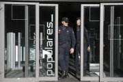 Dos policías salen de la sede central del PP, en la calle Génova de Madrid.-