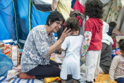 La enfermera Gemma Poca atiende a unos niños en el "Baby Hamam".-VIOLETA PALAZÓN.