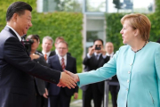 La cancillera alemana Angela Merkel da la bienvenida al presidente chino Xi Jinping.-AXEL SCHMIDT