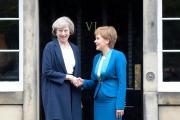 May (izquierda) y Sturgeon se dan la mano en la puerta de Bute House, en Edimburgo, este viernes.-AFP / LESLEY MARTIN