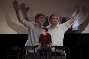 Errejón en el escenario de los cines Palafox (Madrid), ante una imagen suya y de Iglesias tomada en enero de 2015 en València-DAVID CASTRO