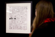 Una mujer mira la plancha de Astérix subastada a beneficio de los familiares de los dibujantes de 'Charlie Hebdo'.-Foto: AFP / KENZO TRIBOUILLARD