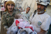 Miembros de los Cascos Blancos llevan en brazos el cuerpo de una niña sacado de las ruinas de un edificio destruido tras un bombardeo en Alepo.-AFP / KARAM AL-MASRI / AFP