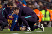 Messi recibe un masaje en el muslo derecho tras quejarse de unas molestias en la segunda mitad del Barça-Valencia.-QUIQUE GARCÍA (EFE)