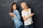 Una chica espía el móvil de su amiga.-123RF
