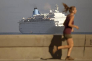 Una mujer corre por el Malecón mientras el crucero Thomson Dream llega a La Habana, el 19 de marzo.-Foto:   AP / DESMOND BOYLAN