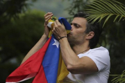 Leopoldo López besa la bandera venezolana tras salir de prisión, el pasado 8 de julio-AP / ARIANA CUBILLOS