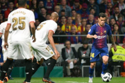 Coutinho conduce el balón ante Nzonzi y Mercado en el Metropolitano.-AFP / PIERRE-PHILIPPE MARCOU